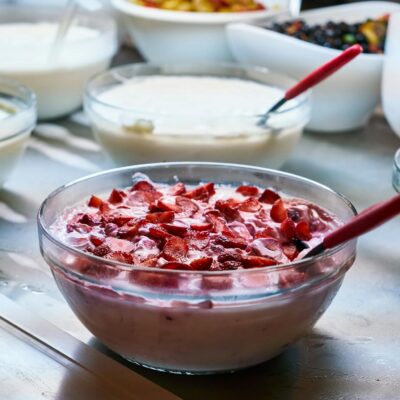 A variety of homemade yogurt dishes with fresh fruit toppings in bowls, perfect for breakfast or a healthy snack.