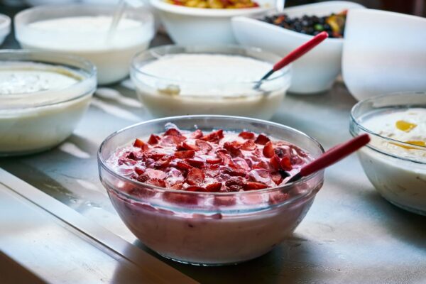 A variety of homemade yogurt dishes with fresh fruit toppings in bowls, perfect for breakfast or a healthy snack.