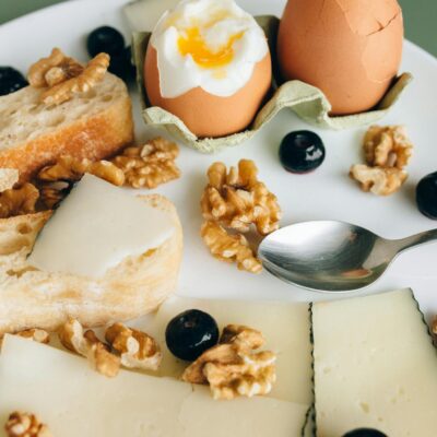 Delicious breakfast plate featuring boiled eggs, walnuts, cheese, and fresh bread.